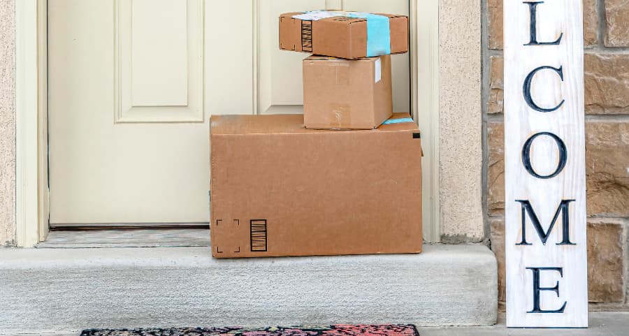 Packages on the doorstep of a home with a welcome sign in Ithaca